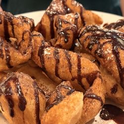 Fried pizza dough with cinnamon sugar, and drizzled with chocolate syrup