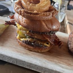 Double cheeseburger burger with bacon and a Mac sauce and onion rings on top!