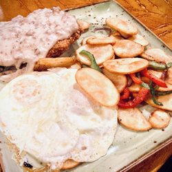 Sierra Gold - Chicken Fried Steak breakfast platter with an/ over-easy eggs and a side of home-fried potato slices.