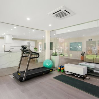 Executive Design & Construction - a gym with treads, exercise equipment, and a glass wall - General Contractors Near Me - Reseda, California
