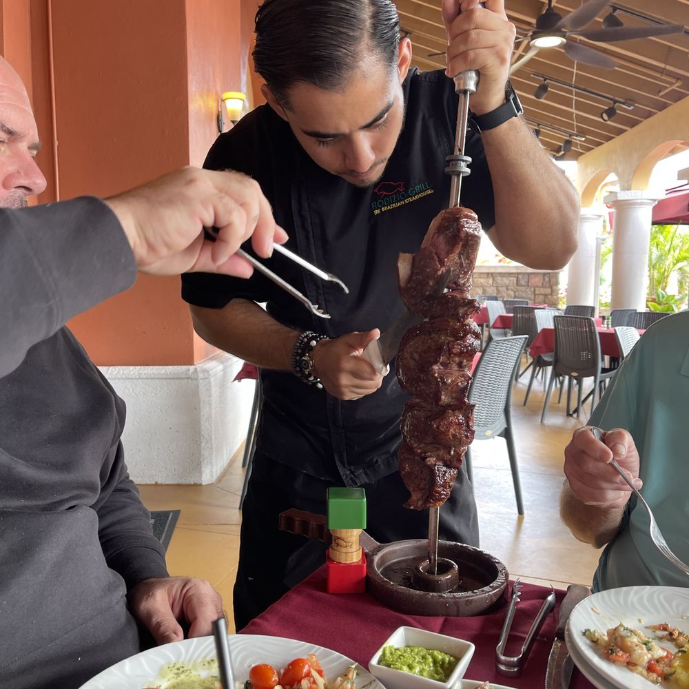 Rodizio Grill Brazilian Steakhouse Estero - Server carving meat! - Steakhouses Near Me - Estero, Florida Rodizio Grill Brazilian Steakhouse Estero - Server carving meat! - Steakhouses Near Me - Estero, Florida