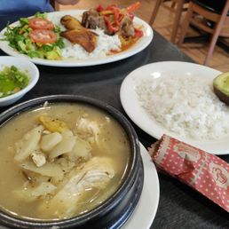 Ajiaco soup with potato and chicken, served with rice and avocado