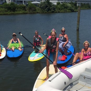 67th Street Paddle Cove - A group of ladies having fun paddle boarding  in their tutus. - Tours Near Me - Ocean City, Maryland