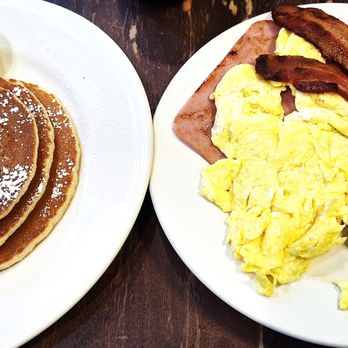 George's - This is a close-up of the pancakes, breakfast meats, and eggs. - American Near Me - New York, New York