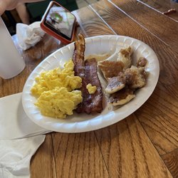 Eggs, bacon, and pancakes with syrup.
