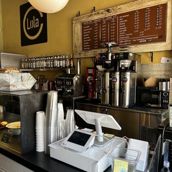 Lola Coffee - a counter with coffee machines and coffee cups - Coffee & Tea Near Me - Phoenix, Arizona