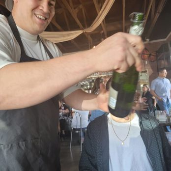 Sage Social Eatery - One of the Cooks helping out with a bottle - Latin American Near Me - Covina, California Sage Social Eatery - One of the Cooks helping out with a bottle - Latin American Near Me - Covina, California