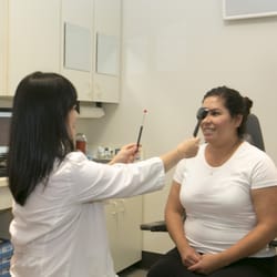 Mai Tang, OD - Dr. Tang is doing a cover test on a patient