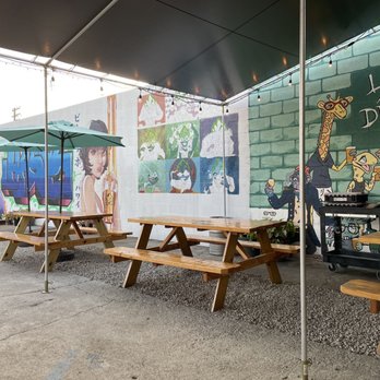 Beer Lab HI - tables and umbrellas in front of a mural - Brewpubs Near Me - Honolulu, Hawaii