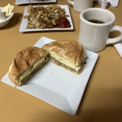 New York Lunch - Sausage, egg and cheese on a hard roll breakfast, home fry potatoes and coffee.