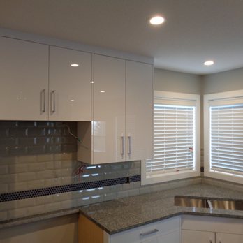 KRM Flooring - a kitchen with white cabinets and granite countertops - Flooring Near Me