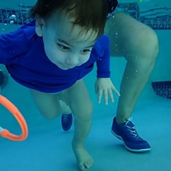 A toddler getting the rings under water!
