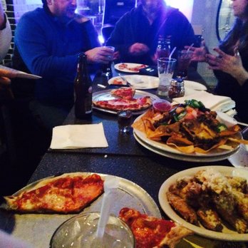 Pit Stop Cafe - a group of people eating pizza - Dive Bars Near Me - Milford, Connecticut