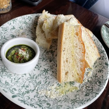 Fire & the Feast - Focaccia bread with pesto spread on the side. - Italian Near Me - Edmonds, Washington Fire & the Feast - Focaccia bread with pesto spread on the side. - Italian Near Me - Edmonds, Washington