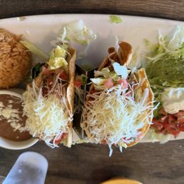 Crispy Chicken Tacos with flavorful rice and beans. Served with salsa, guacamole and sour cream .