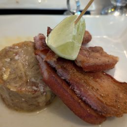 Pork Belly Mofungo - Crispy pork belly served with garlic and olive oil mashed green plantains topped with pickled onion