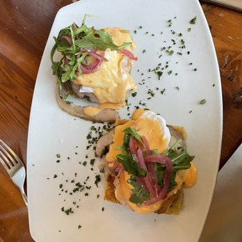 The Kenwood - Focaccia Eggs Benedict with porchetta, arugula, and Calabrian chili hollandaise. So good! - New American Near Me - Minneapolis, Minnesota