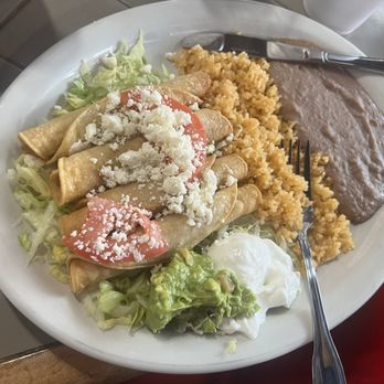 El Sol De Mexico - Sprinkled cheese over the Flautas with guacamole, sour cream, lettuce Sliced tomatoes with rice and beans - Mexican Near Me - Kerrville, Texas
