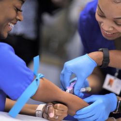 The College of Health Care Professions - Medical Assistant students helping each other learn how to draw blood.