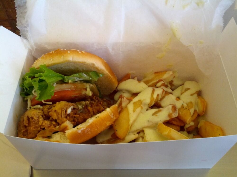 Shark burger, lettuce, tomatoes, pineapple, coleslaw, fries with garlic