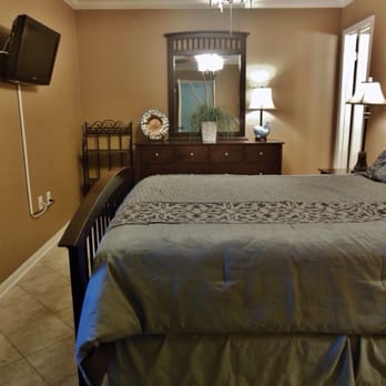 Island Sunrise - Master bedroom features a Queen size bed, flat screen TV mounted to the wall, and a private bathroom. - Vacation Rentals Near Me - Gulf Shores, Alabama Island Sunrise - Master bedroom features a Queen size bed, flat screen TV mounted to the wall, and a private bathroom. - Vacation Rentals Near Me - Gulf Shores, Alabama