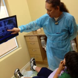 Eduardo M Gabuten & Associates - Each room has a TV. You can watch your favorite show or look at your x-rays:) The assistant showing Noah his incoming teeth:)