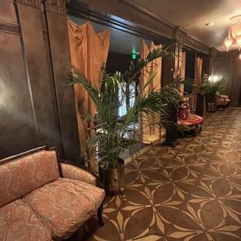 Ash Bar - a long hallway with a couch and a potted plant - Cocktail Bars Near Me - Baltimore, Maryland