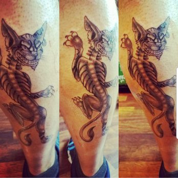 Chapter One Tattoo - My husband's calf with a distorted Cheshire cat from the old video game, Alice - Tattoo Near Me - San Diego, California Chapter One Tattoo - My husband's calf with a distorted Cheshire cat from the old video game, Alice - Tattoo Near Me - San Diego, California