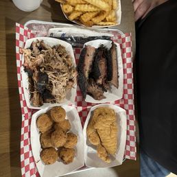 Choice of 3 Meats including pulled pork, brisket, and chicken tenders with hush puppies and fries Choice of 3 Meats including pulled pork, brisket, and chicken tenders with hush puppies and fries