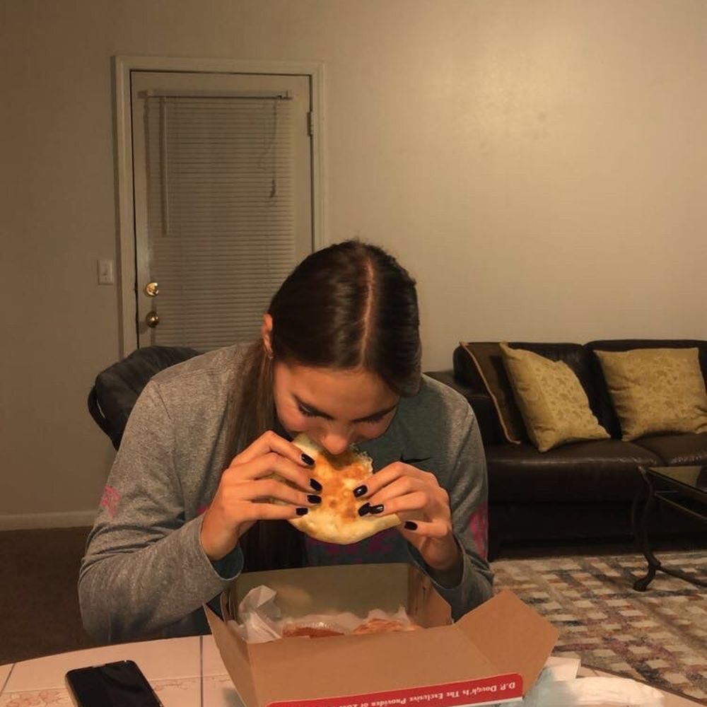 a woman sitting at a table eating a doughnut