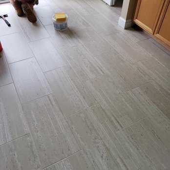 Bensalem Flooring - a man in a green shirt on the floor - Flooring Near Me
