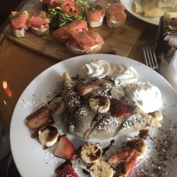 Le Cafe De Paris - Nutella crepe with banana and strawberry, salmon for two in the background - Coffee & Tea Near Me - Orlando, Florida