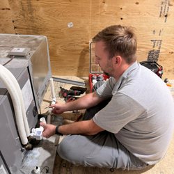 SmartWay Appliance Repair - Professional HVAC technician installing and servicing a residential heating and cooling system.