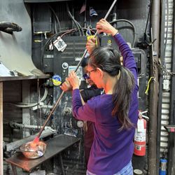 Vetro Glassblowing Studio - Adding color to the glass piece.