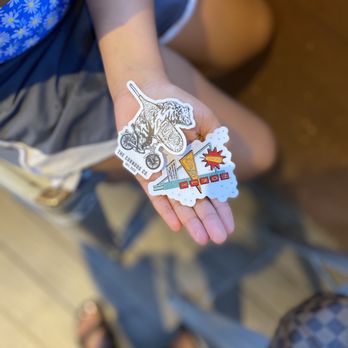 The Corndog Company - Austin - a person's hand with stickers - Food Trucks Near Me - Austin, Texas