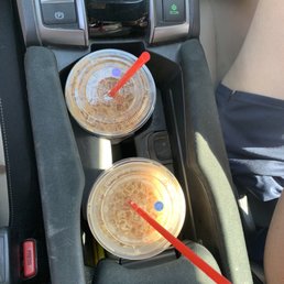 two plastic cups in the center console of a car two plastic cups in the center console of a car