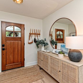 Pink Cube Development - Renovated foyer with wood door replacement and round mirror design - General Contractors Near Me Pink Cube Development - Renovated foyer with wood door replacement and round mirror design - General Contractors Near Me