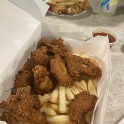 Philly's Pizza - Foreground: 12-piece Chicken Wings and Fries. Background: half of 4-piece Chicken Strips and Fries.