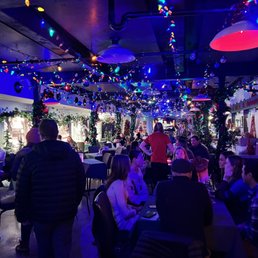 a crowded restaurant with christmas lights