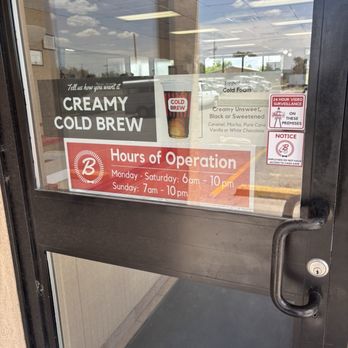 Blake's Lotaburger - Follow the instructions please - A glass door shows signage for Blake's Lotaburger in Moriarty, NM, including hours of operation from 6 am to 10 pm Monday through Saturday and 7 am to 10 pm on Sunday. Additional notices about surveillance and employee access are visible, along with a menu offering creamy cold brew and flavored options. The reflection of the parking lot and sky can be seen on the glass. - Burgers Near Me - Moriarty, New Mexico