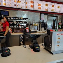 ows a woman standing at a counter in a fast food restaurant ows a woman standing at a counter in a fast food restaurant