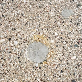 Sure-Dry - After Sure-Dry: repair discoloration - A concrete patch is embedded in a gravel surface composed of small stones and pebbles. - Waterproofing Near Me - Menasha, Wisconsin