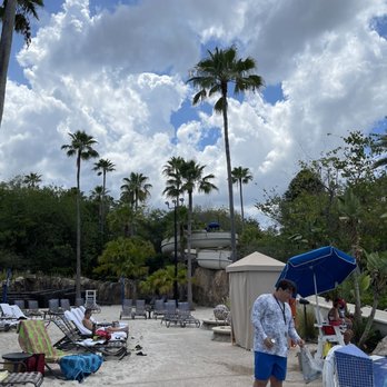 Beach Club - a man holding an umbrella on the beach - Bars Near Me - Orlando, Florida