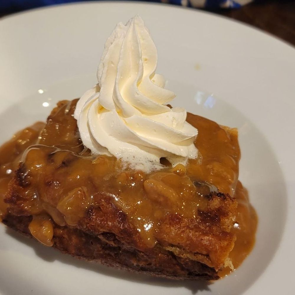 Nola Southern Grill - Bread pudding topped with a rum sauce and homemade whipped cream - New American Near Me - Slidell, Louisiana Nola Southern Grill - Bread pudding topped with a rum sauce and homemade whipped cream - New American Near Me - Slidell, Louisiana
