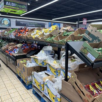 ALDI - The image shows the produce section of an ALDI grocery store in Clifton, NJ, with various fruits such as bananas, strawberries, and other produce arranged in cardboard boxes and on display shelves. The store has bright lighting, a tiled floor, and signage indicating low prices and high quality. - Grocery Near Me - Clifton, New Jersey