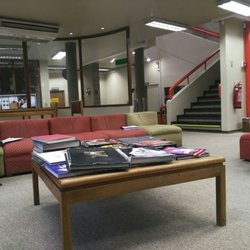 Biblioteca Municipal de Providencia Mauricio Litvak - Perspectiva del primer piso, sector en donde encontrarás sofás y la colección de libros a tu disposición, junto a los bibliotecarios.