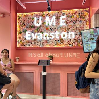 Ume Tea - Pink-themed UME Evaston interior features a plush toy wall, illuminated UME sign, and a digital ordering kiosk with customers nearby. - Bubble Tea Near Me - Evanston, Illinois