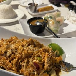 Pad Thai with chicken, summer rolls with shrimp in the background. Pad Thai with chicken, summer rolls with shrimp in the background.