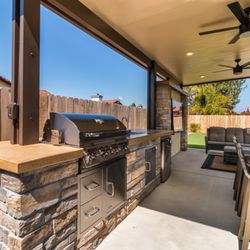 Harmony Design and Build - Beautiful backyard upgrade with a shaded patio, outdoor kitchen, and stylish seating areas, creating the perfect entertaining space.