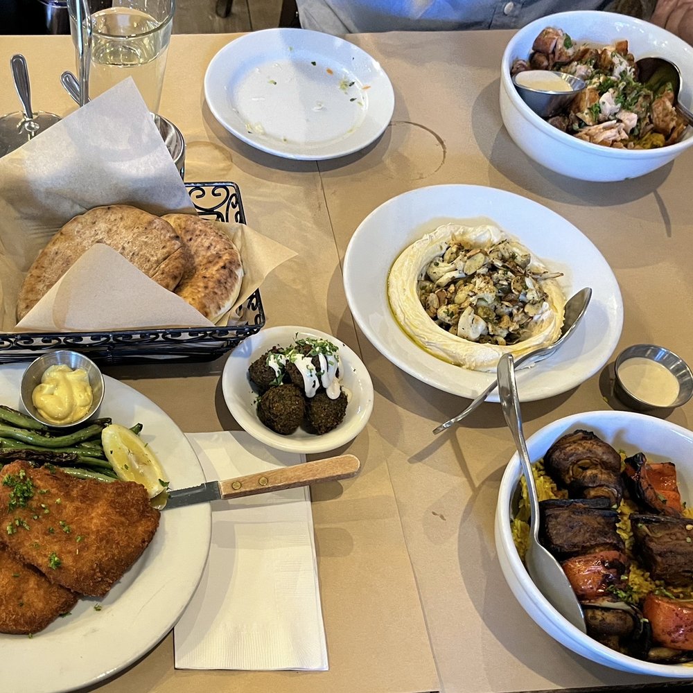 Oren's Hummus - Top down, left to right: Chicken rice bowl, white and wheat pita, falafels, cauliflower hummus, schnitzel de noir, and veggie rice bowl - Mediterranean Near Me - Mountain View, California